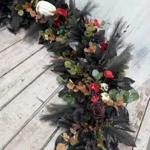 Black Halloween artificial flower garland for doorway decor.